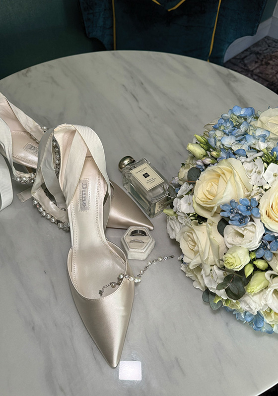 Brides shoes, Jo Malone perfume and blue and cream rose bouquet